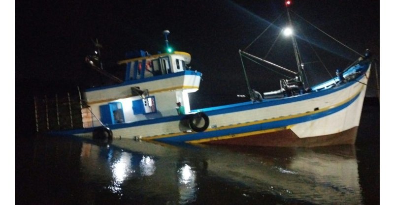 Barco de pesca com oito tripulantes bate nos molhes e fica parcialmente submerso em Laguna
