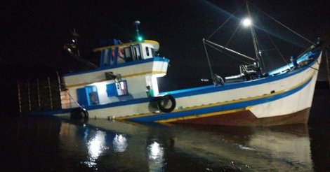 Barco de pesca com oito tripulantes bate nos molhes e fica parcialmente submerso em Laguna